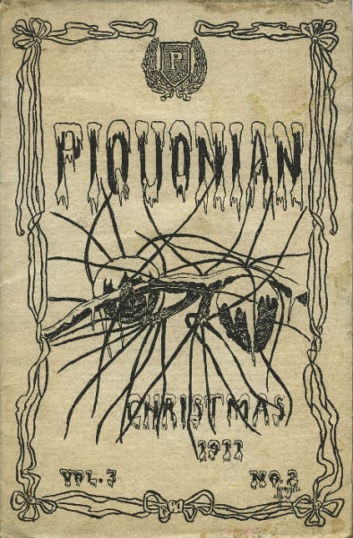 A scan of the cover of a publication called the Piquonian. It is tan with black illustrations of a branch of a pine tree with two pinecones. The top reads PIQUONIAN and the bottom reads CHRISTMAS Vol. 3 1911 No. 2. All of the words have snow on them, as do the pinecones. There is a ribbon border around the outside and a seal with a P on it.